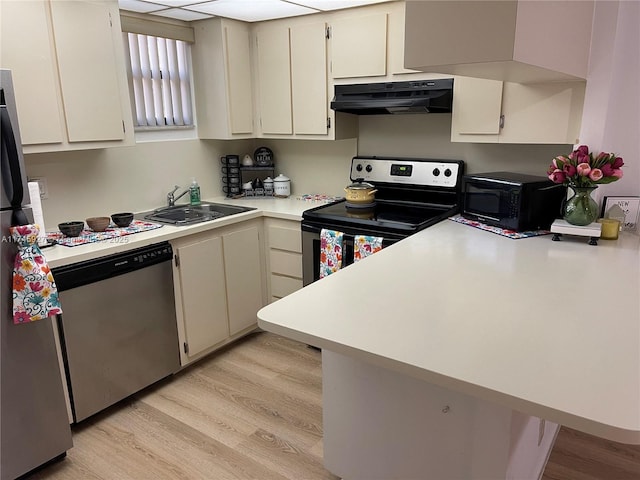 8290 Lake Dr Unit 223, Doral, FL 33166 - kitchen featuring light countertops, light wood-type flooring, under cabinet range hood, a sink, and appliances with stainless steel finishes