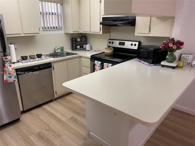8290 Lake Dr Unit 223, Doral, FL 33166 - kitchen featuring light countertops, a sink, light wood-style flooring, under cabinet range hood, and stainless steel appliances