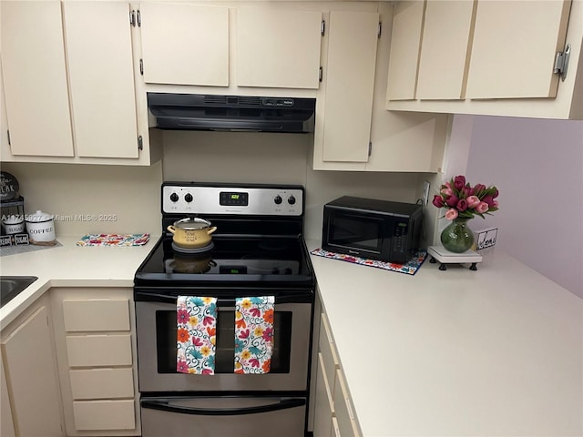 8290 Lake Dr Unit 223, Doral, FL 33166 - kitchen featuring light countertops, range hood, electric range, white cabinets, and black microwave