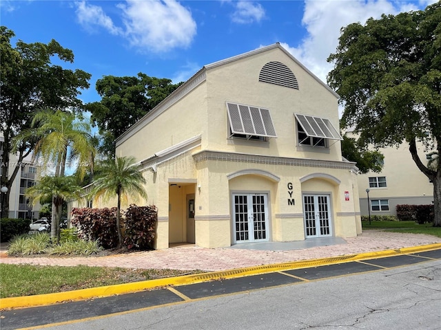 8290 Lake Dr Unit 223, Doral, FL 33166 - view of front of house featuring roof mounted solar panels, stucco siding, and french doors