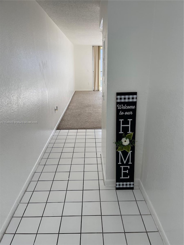 8225 Lake Dr Unit 502, Doral, FL 33166 - corridor with light tile patterned flooring, baseboards, a textured wall, and a textured ceiling