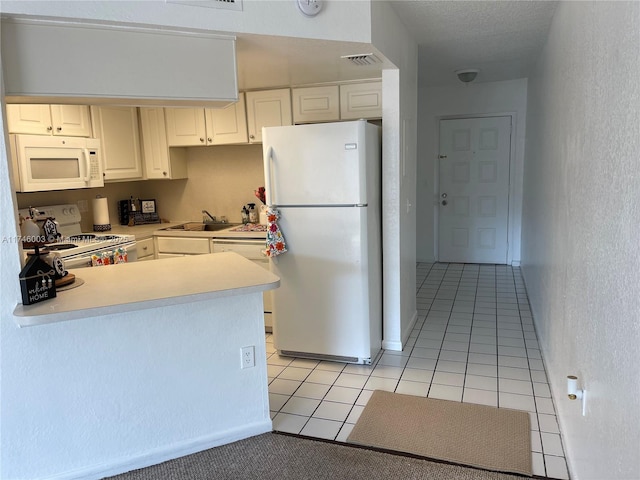 8225 Lake Dr Unit 502, Doral, FL 33166 - kitchen with a sink, white cabinetry, light tile patterned floors, white appliances, and visible vents