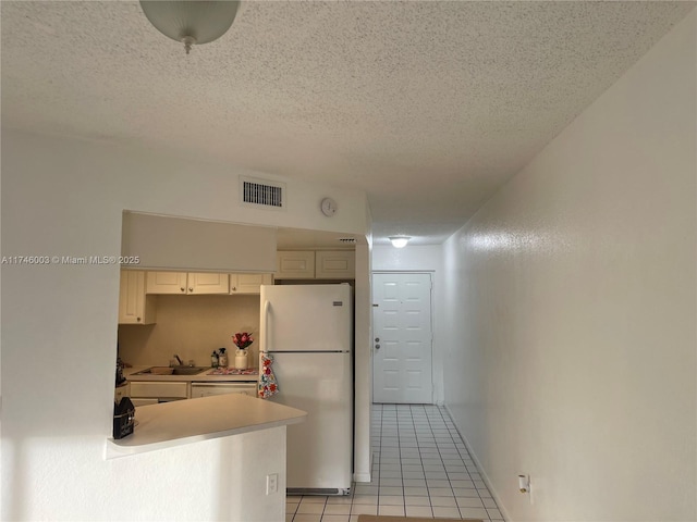8225 Lake Dr Unit 502, Doral, FL 33166 - kitchen featuring a textured ceiling, visible vents, a sink, light tile patterned floors, and freestanding refrigerator
