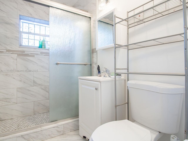 bathroom with vanity, a shower with door, and toilet