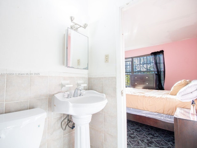 bathroom with tile patterned flooring, tile walls, and toilet