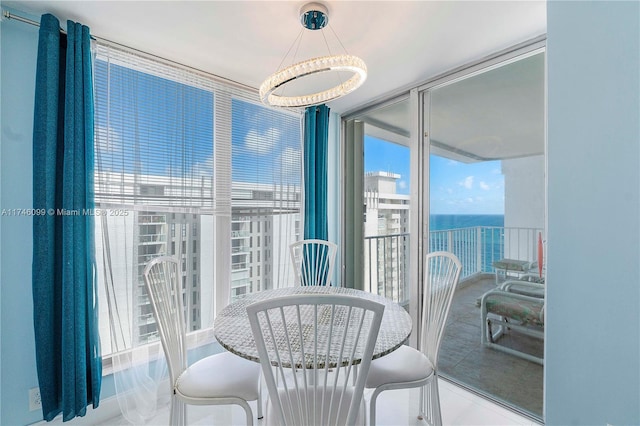 dining space featuring expansive windows and a water view