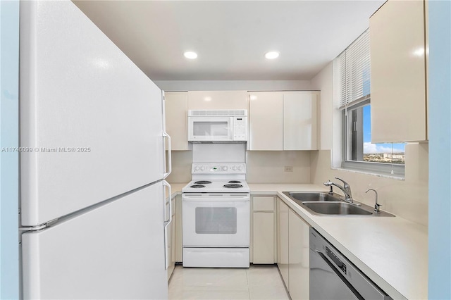 kitchen with sink, white cabinets, and white appliances