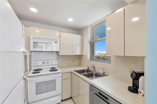 kitchen with white appliances, sink, and white cabinets