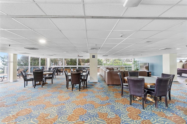 dining space with a drop ceiling and a wealth of natural light