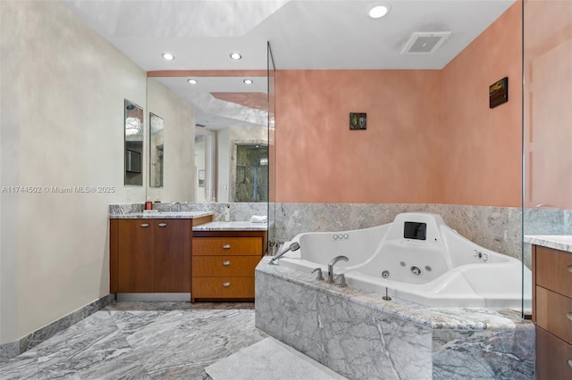 bathroom featuring vanity and independent shower and bath