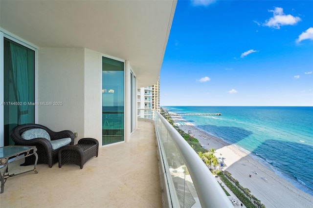 balcony with a water view and a beach view