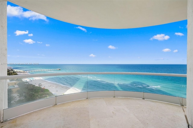 balcony featuring a beach view and a water view