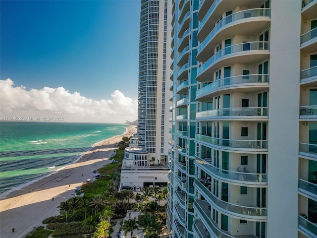 view of building exterior featuring a water view and a view of the beach