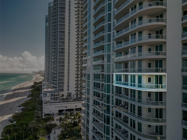 view of building exterior with a water view and a view of the beach