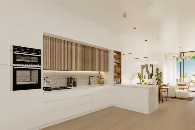 kitchen featuring pendant lighting, light hardwood / wood-style flooring, gas cooktop, white cabinetry, and tasteful backsplash