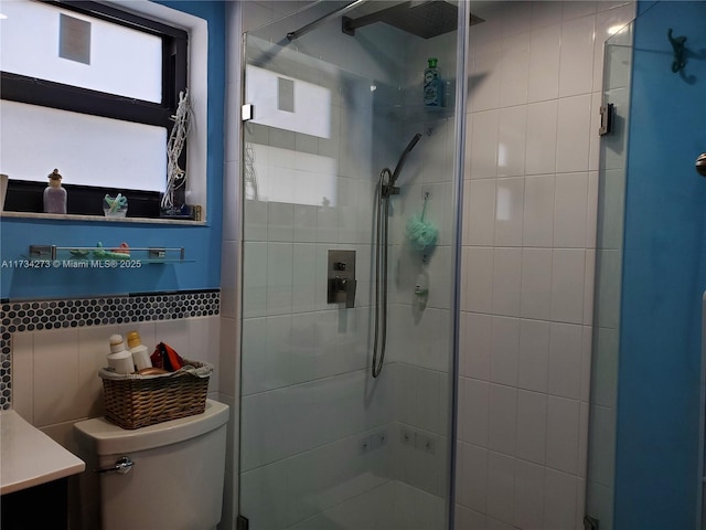 bathroom featuring vanity, decorative backsplash, toilet, and walk in shower