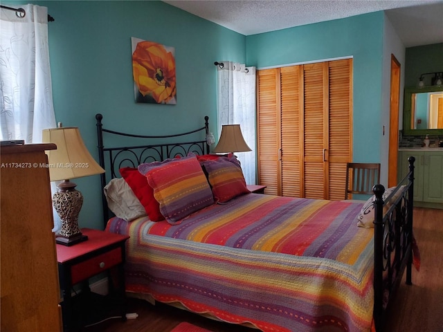 bedroom featuring wood-type flooring, a closet, and a textured ceiling