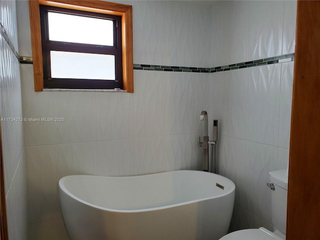 bathroom featuring toilet, a bathing tub, and tile walls