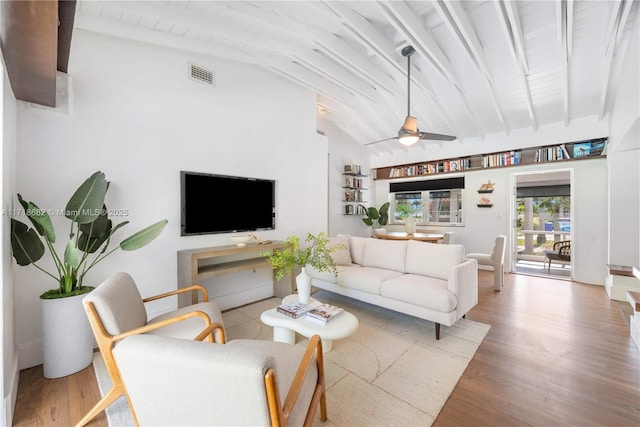 living room featuring hardwood / wood-style flooring, ceiling fan, and lofted ceiling with beams