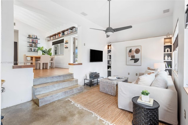 living room with ceiling fan, concrete flooring, and vaulted ceiling