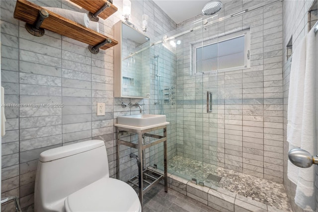 bathroom with toilet, sink, tile walls, and walk in shower