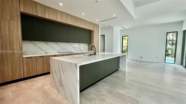 kitchen featuring tasteful backsplash, a large island, and sink