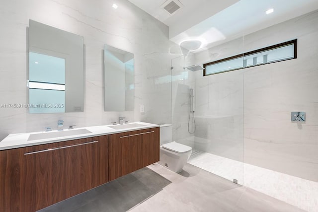 bathroom featuring vanity, toilet, tile walls, and a tile shower