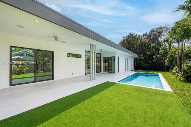 view of pool with a yard, a patio area, and ceiling fan