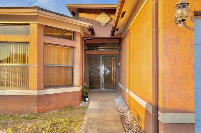 doorway to property featuring stucco siding