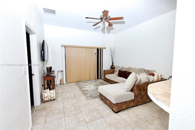 living area with light tile patterned floors, visible vents, and a ceiling fan