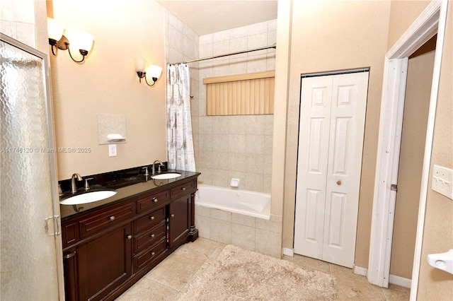 full bathroom featuring double vanity, a closet, and a sink