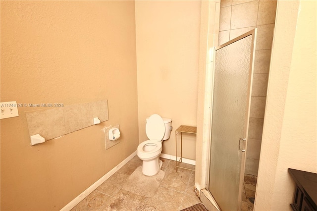 full bath featuring toilet, a stall shower, and baseboards