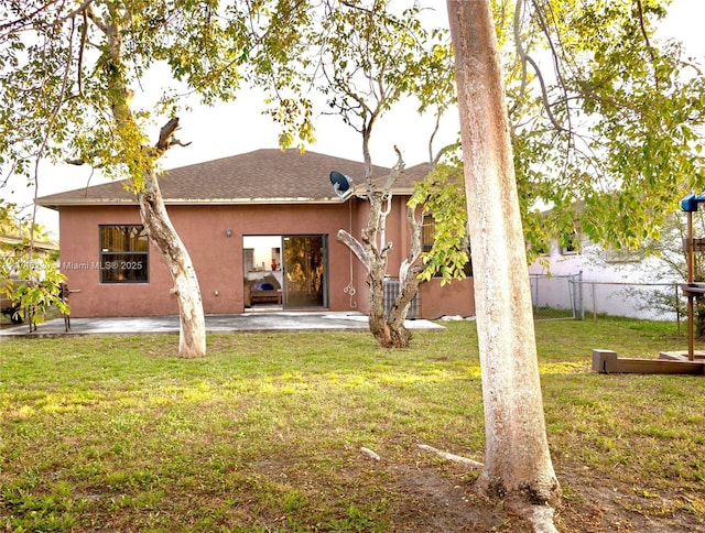 back of property featuring a patio area, fence, a lawn, and stucco siding