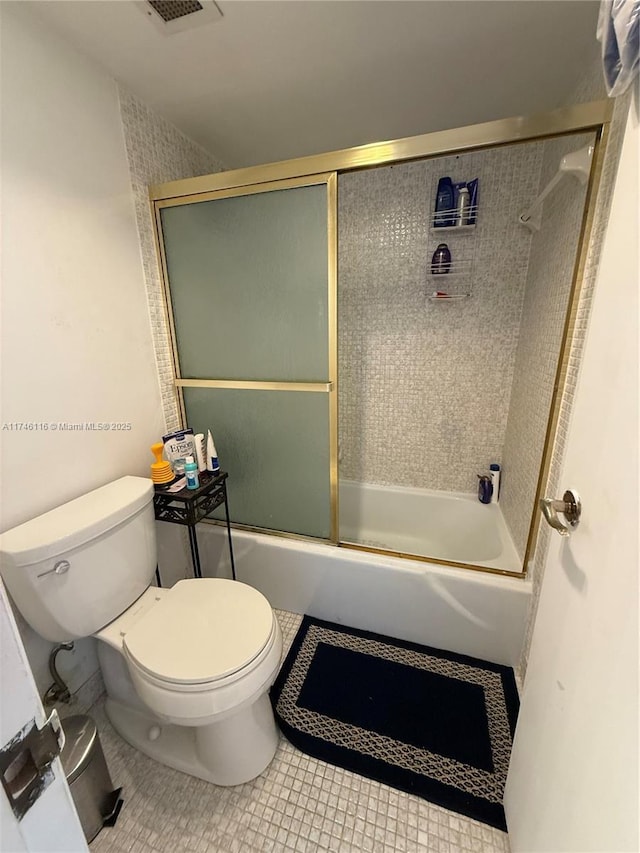 bathroom featuring enclosed tub / shower combo, tile patterned floors, and toilet