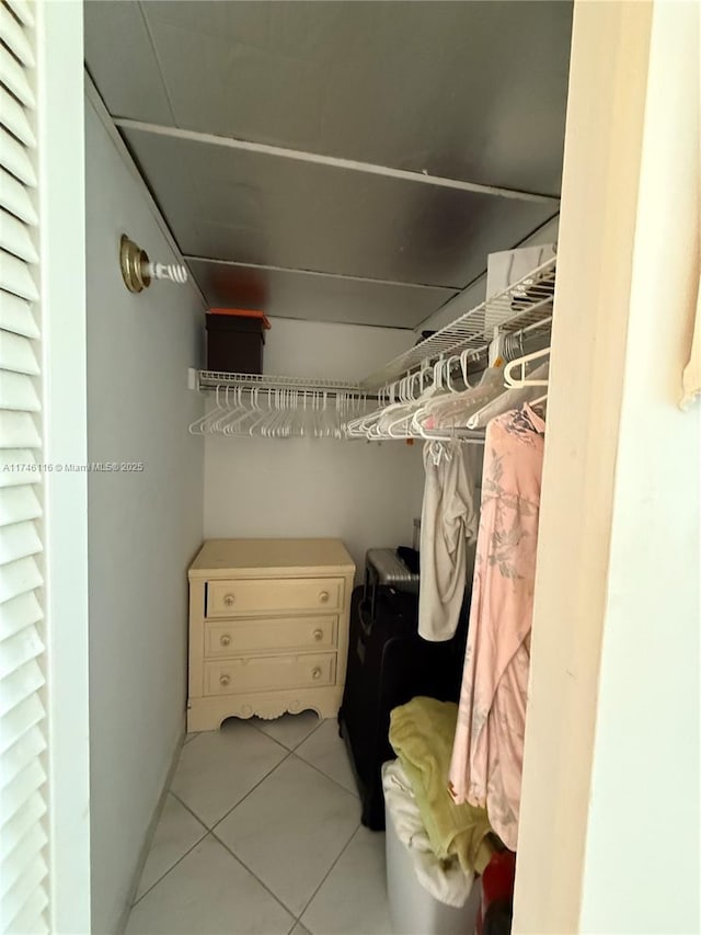 walk in closet with light tile patterned floors