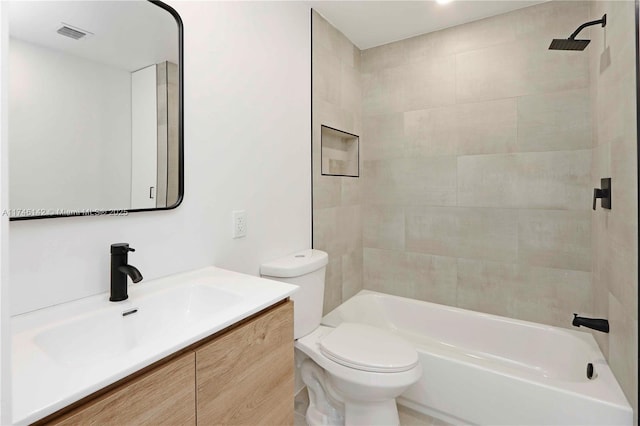 full bathroom with tiled shower / bath, vanity, and toilet