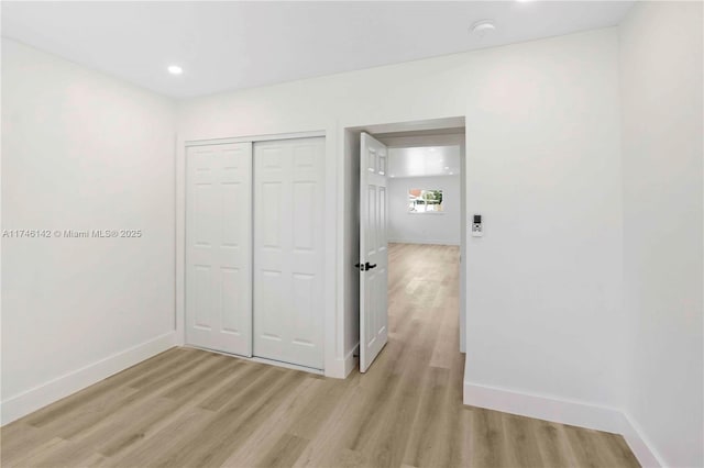 unfurnished bedroom featuring light hardwood / wood-style floors and a closet