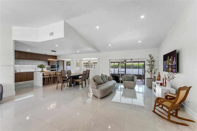 living area featuring lofted ceiling, baseboards, visible vents, and recessed lighting