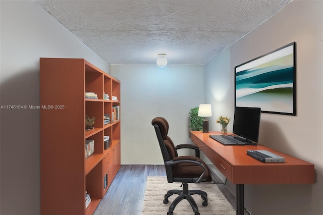 office with wood-type flooring and a textured ceiling