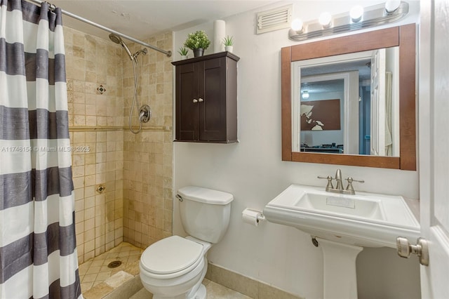 bathroom with toilet, sink, and a shower with curtain