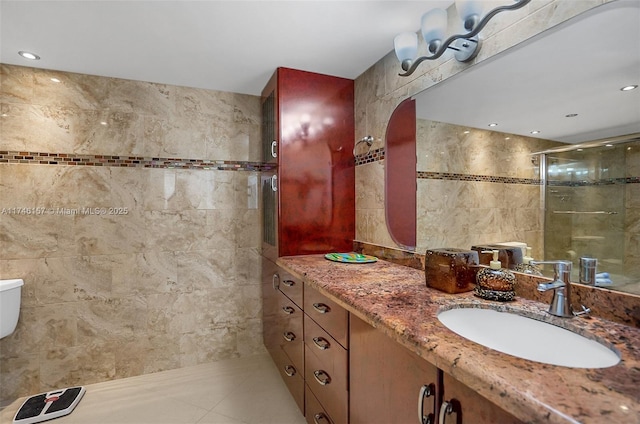 bathroom with tile patterned floors, toilet, an enclosed shower, tile walls, and vanity