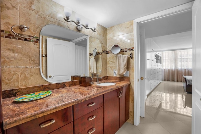 bathroom featuring tile patterned flooring, vanity, and tile walls