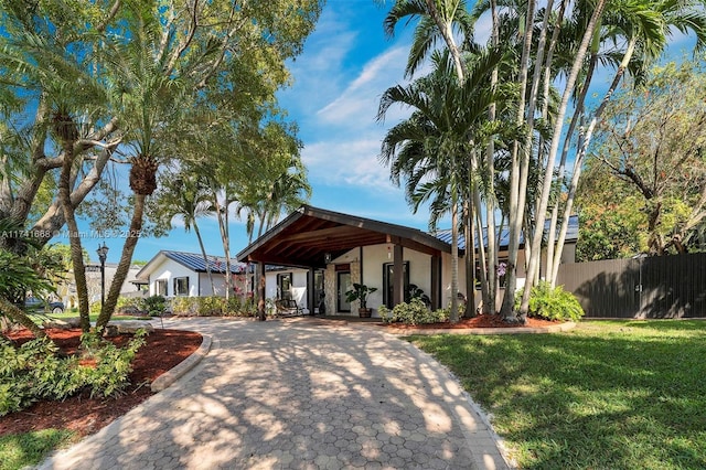 view of front of home featuring a front yard, fence, driveway, and stucco siding