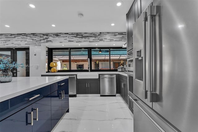 kitchen with high quality fridge, recessed lighting, a sink, marble finish floor, and light countertops