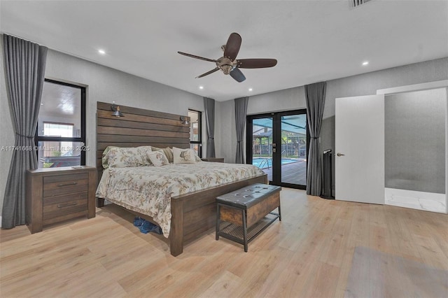 bedroom with access to outside, french doors, multiple windows, and light wood-style flooring