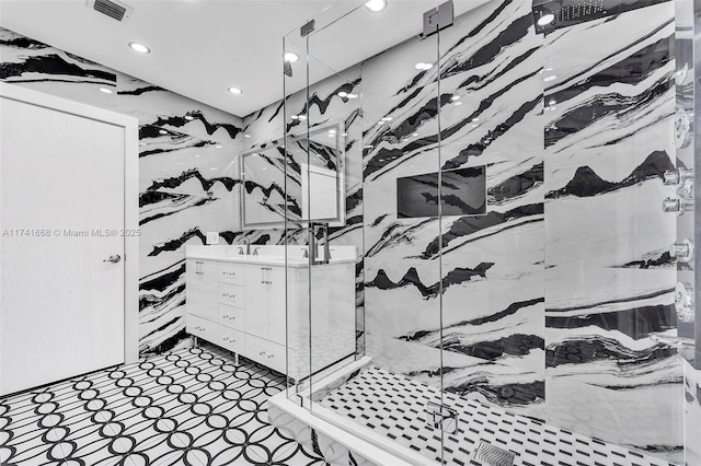 interior details featuring double vanity, a marble finish shower, visible vents, and recessed lighting