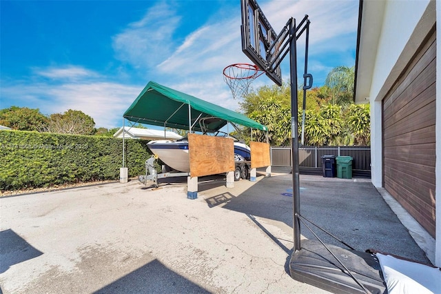 view of patio featuring fence and a carport