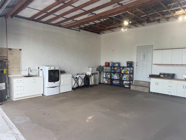 garage with a sink, washing machine and dryer, and electric water heater