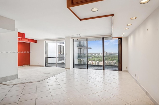 tiled spare room featuring floor to ceiling windows