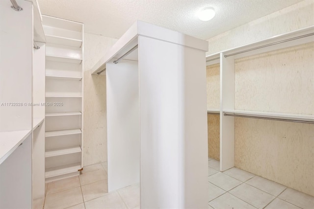 walk in closet with light tile patterned floors